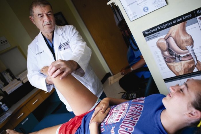 Pediatric orthopedist Dr. Lyle Micheli examines 16-year-old Margaret Chouinard's knee at Boston Children's Hospital. (Photo courtesy of Katherine C. Cohen)